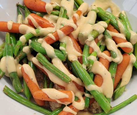 A woman in athletic wear sitting on a yoga mat indoors, smiling.