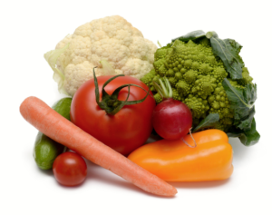 A woman in athletic wear sitting on a yoga mat indoors, smiling.